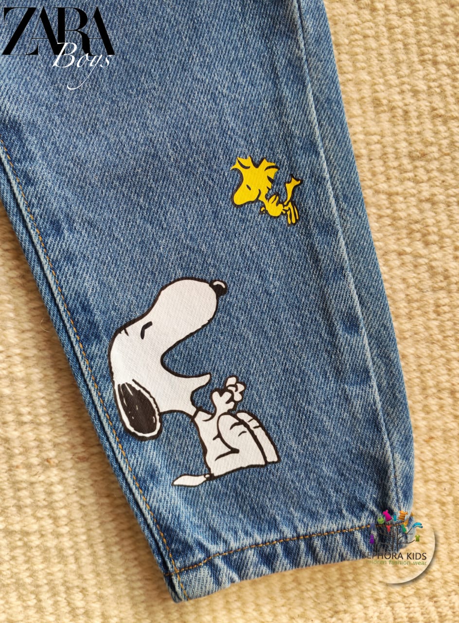 Blue jeans with Snoopy designs on a textured surface