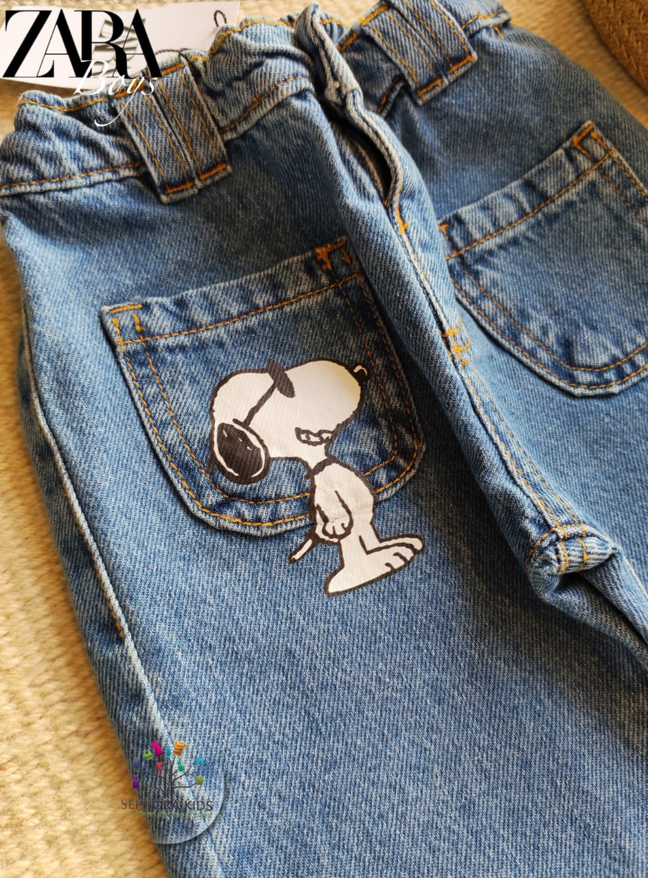 Blue jeans with Snoopy designs on a textured surface