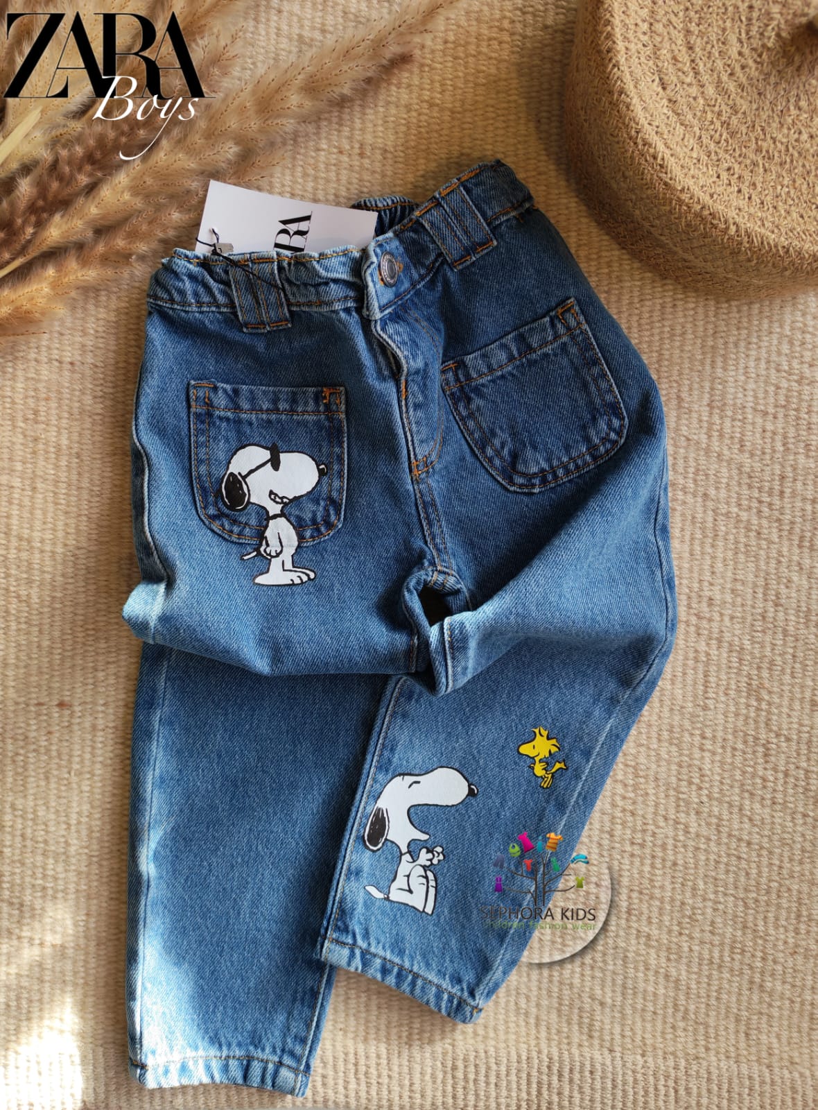 Blue jeans with Snoopy designs on a textured surface