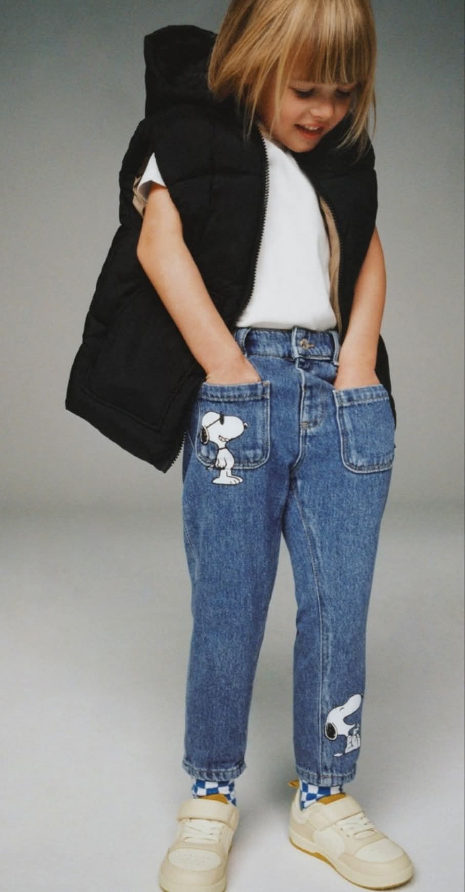Blue jeans with Snoopy designs on a textured surface