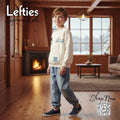 Child wearing a white sweatshirt with text in a cozy living room setting, featuring 'Lefties' and 'Sephora Kids'.